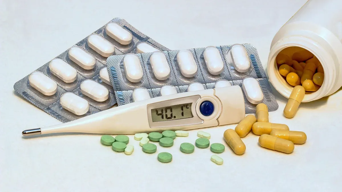 Tabletki w blistrach i termometr pokazujący 40,1°C, ibuprofen czy paracetamol na gorączkę